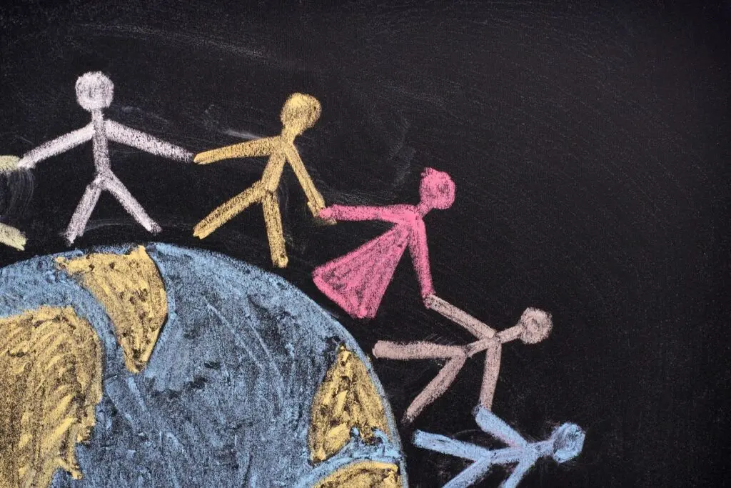Chalk figures holding hands around Earth.