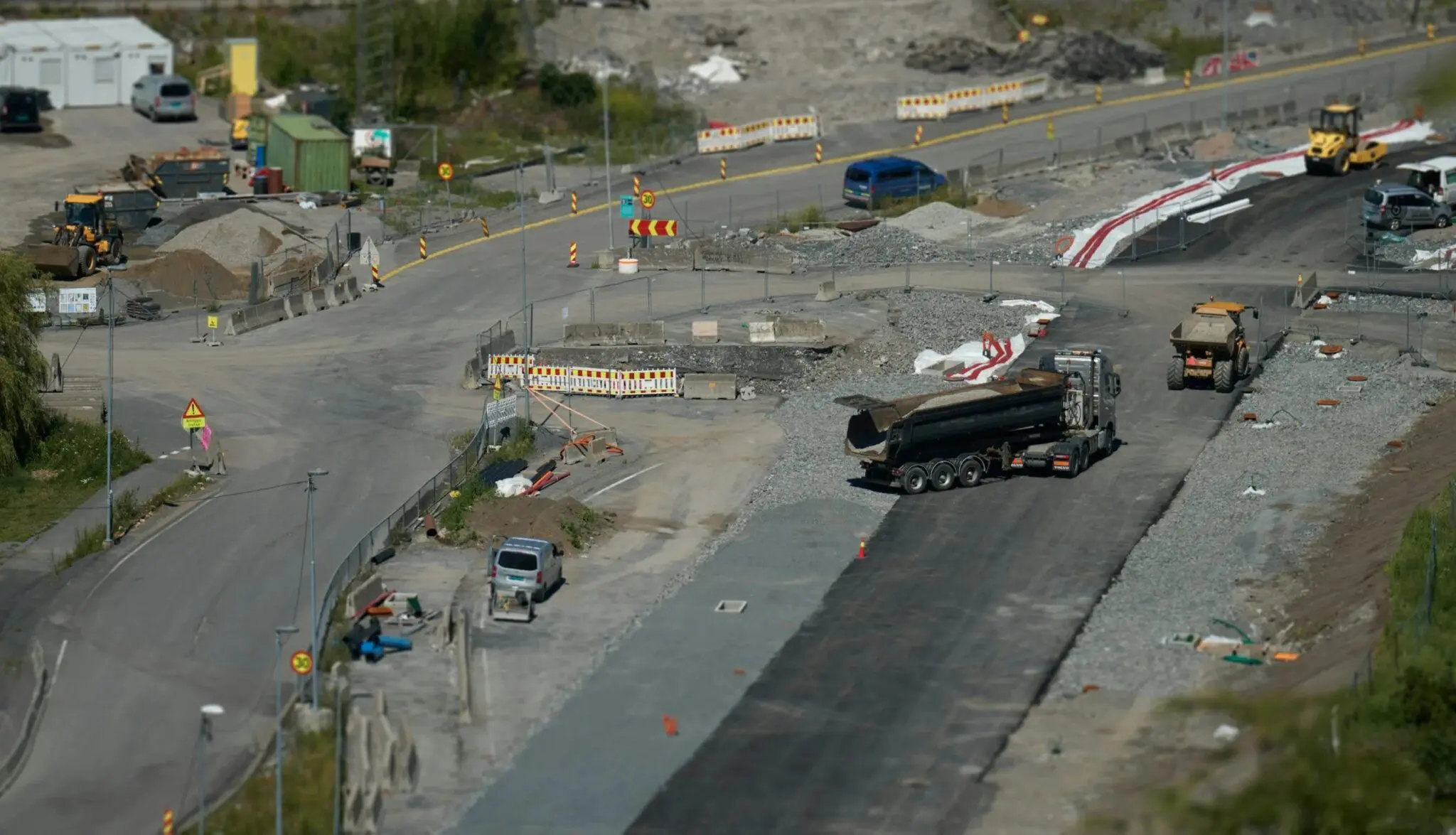 Road construction site with trucks and equipment.