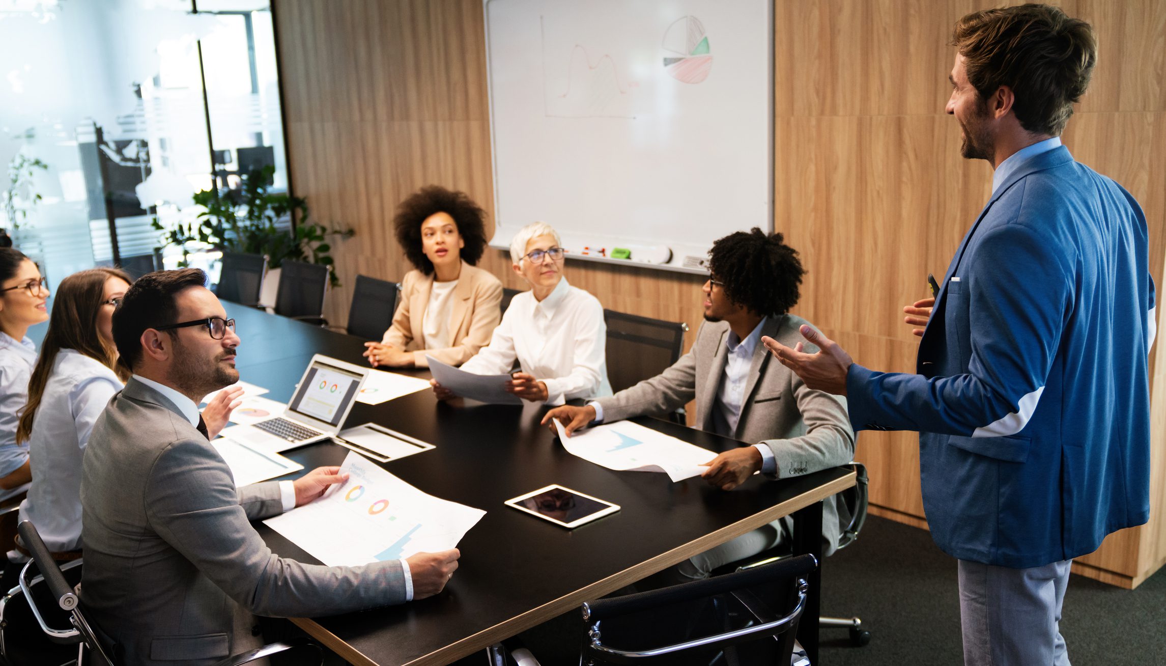 Diverse professionals engaged in a collaborative meeting around a conference table.