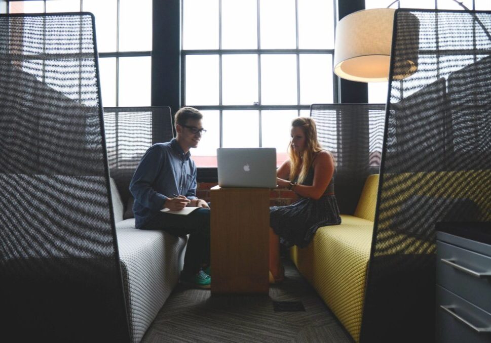 Two people working at a laptop.