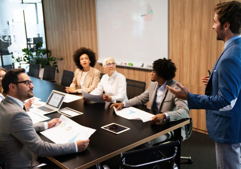 Diverse professionals engaged in a collaborative meeting around a conference table.